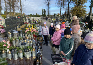 Dzieci stoją przed grobem olimpijczyka