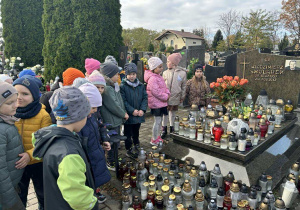 Dzieci stoją przed grobem piłkarza