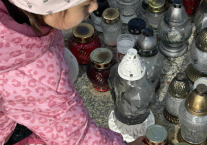 Dziewczynka stawia znicz