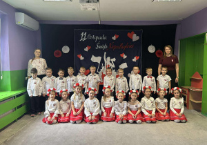 Zdjęcie grupowe na tle dekoracji z okazji Święta Niepodległości.