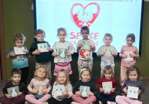 dzieci prezenują wykonane karty świąteczne