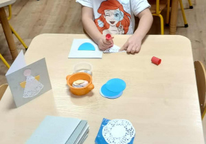 dziewczynka ozdabia kartę świąteczną