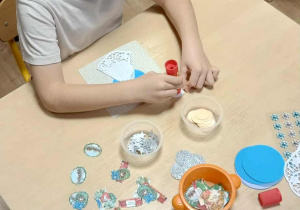 chłopiec ozdabia kartę świąteczną