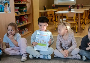 chłopiec prezentuje ilustrację dotyczącą praw dziecka