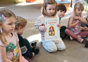 dziewczynka prezentuje ilustrację dotyczącą praw dziecka