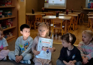 dziewczynka prezentuje ilustrację dotyczącą praw dziecka