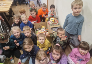 Dzieci z zebranymi w przedszkolu herbatkami dla seniorów.
