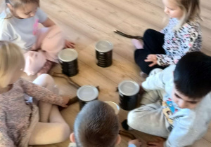 dzieci graja na metalowych puszkach