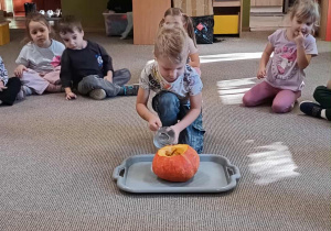 chłopiec wlewa ocet do wnetrza dyni