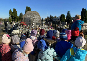 Dzieci na cmentarzu przy grobie żołnierzy.