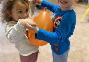 Dzieci tańczą z balonem.