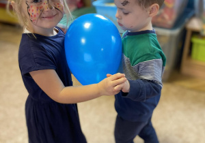Dzieci tańczą z balonem.