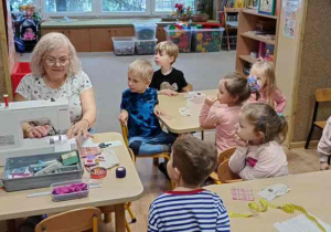 Pani krawcowa demonstruje jak działa maszyna do szycia