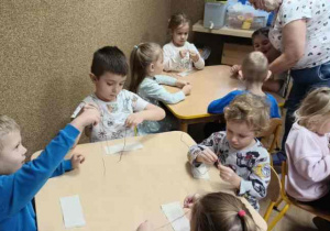 dzieci przewlekaja nitki przez igłę