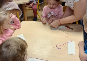 Pani krawcowa pomaga nawekać igłę