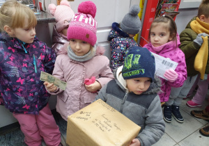 Dzieci na poczcie wysyłają paczkę ze świątecznymi kartkami.