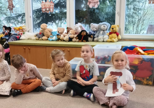 dziewczynka trzyma ilustrację z misiem