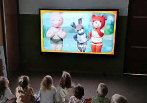 dzieci oglądają bajkę o Misiu Uszatku na ekranie