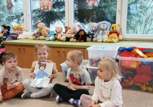 dziewczynka trzyma ilustrację z misiem