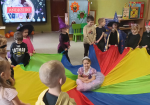 dziewczynka w stroju królewny siedzi na chuście animacyjnej