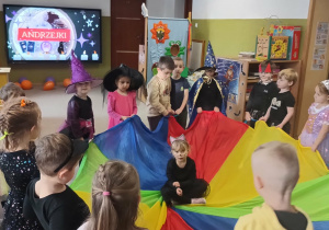 dziewczynka przebrana za kota siedzi na chuście animacyjnej