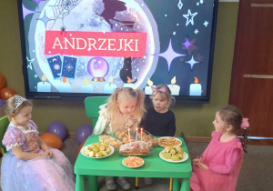 dziewczynka zdmuchuje świeczki urodzinowe