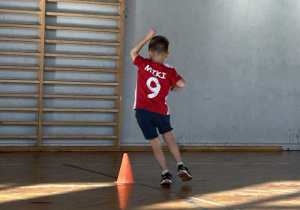 Chłopiec obiega pachołek