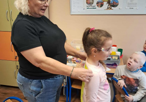 Pani mierzy plecy dziewczynki