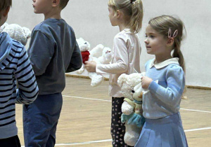 Dzieci stoją z własnymi misiami