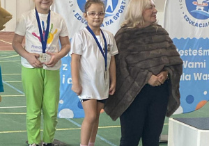 Dziewczynki na podium razem z Panią Naczelnik W Edukacji, Kultury i Sportu.ydziału