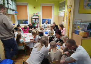 Dzieci malują ozdoby wspólnie z rodzicami.