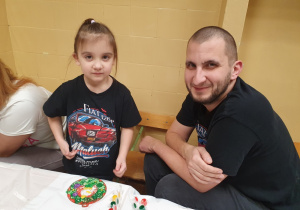 Dzieci malują ozdoby wspólnie z rodzicami.