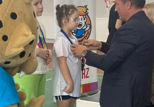 Dziewczynka otrzymuje medal