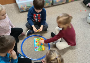 dzieci układają obrazki z figur