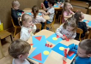 dzieci układają postać Świętego Mikołaja z figur geometrycznych