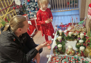 Dzieci z rodzicami kupują świąteczne ozdoby.