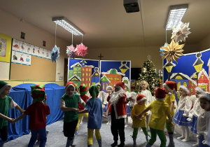 Dzieci tańczą w kółkach.