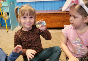 Dziewczynka pokazuje sztabkę złota