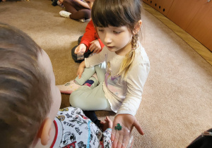 Dzieci oglądają kolorowe kamienie