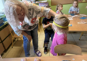 Krawcowa mierzy obwód głowy.