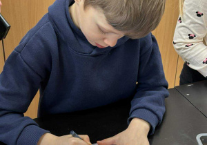 Chłopiec koloruje obrazek