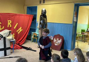 Chłopiec prezentuje w jaki sposób rycerz odbywał pokutę.