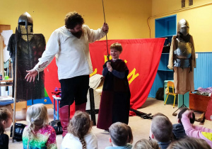 Chłopiec prezentuje miecz rycerski.