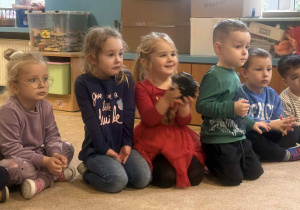 Dzieci słuchają i oglądają sprzęt fotograficzny.