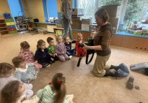Dzieci słuchają i oglądają sprzęt fotograficzny.