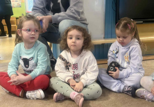 Dzieci słuchają i oglądają sprzęt fotograficzny.