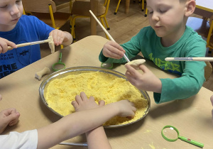 dzieci oglądają skamieliny dinozaura