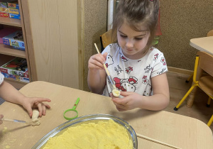 dziewczynka oczyszcza skamielinę pędzelkiem