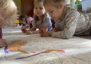 dzieci kolorują kontury dinozaura