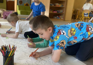 dzieci kolorują kontury dinozaura